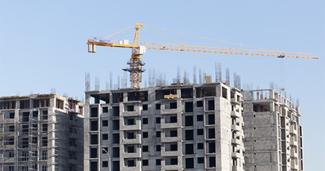 Apartment buildings in construction with large crane on top