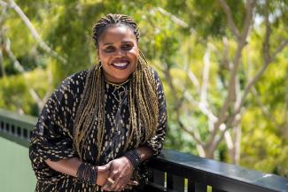 Flemington tenant Rose stands on a balcony smiling